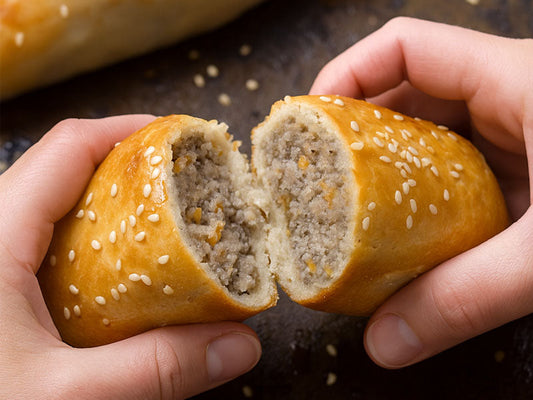 hands breaking apart a homemade gluten free sausage roll