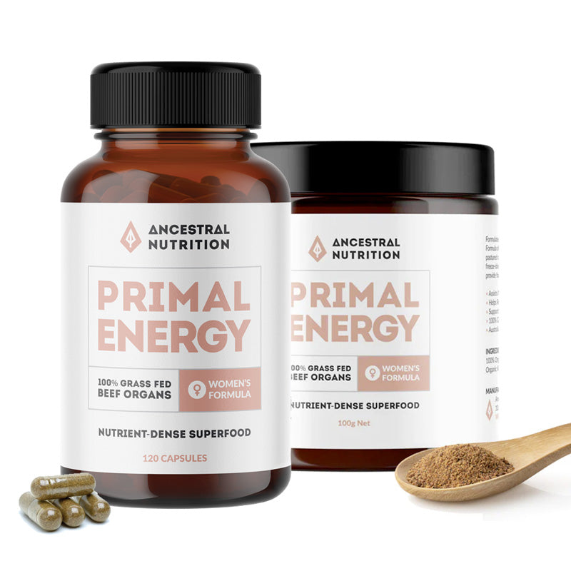 Two bottles of Ancestral Nutrition's Primal Energy Women beef organ supplements with capsules visible in front, against a white background.